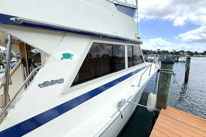 Slide: The Image of 1986 Viking 35 Convertible yacht docked at marina, featuring sleek design and nautical details. - 2