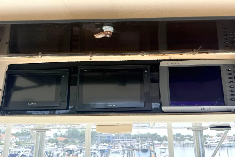 Slide: The Image of Garmin navigation displays on a 1986 Viking 35 Convertible boat, overlooking a marina. - 24