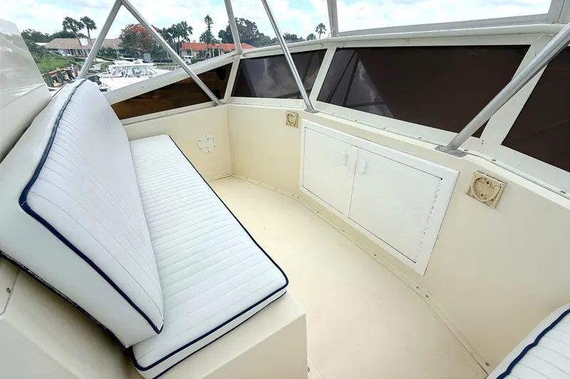 Slide: The Image of 1986 Viking 35 Convertible boat interior with cushioned seating and storage cabinets. - 26