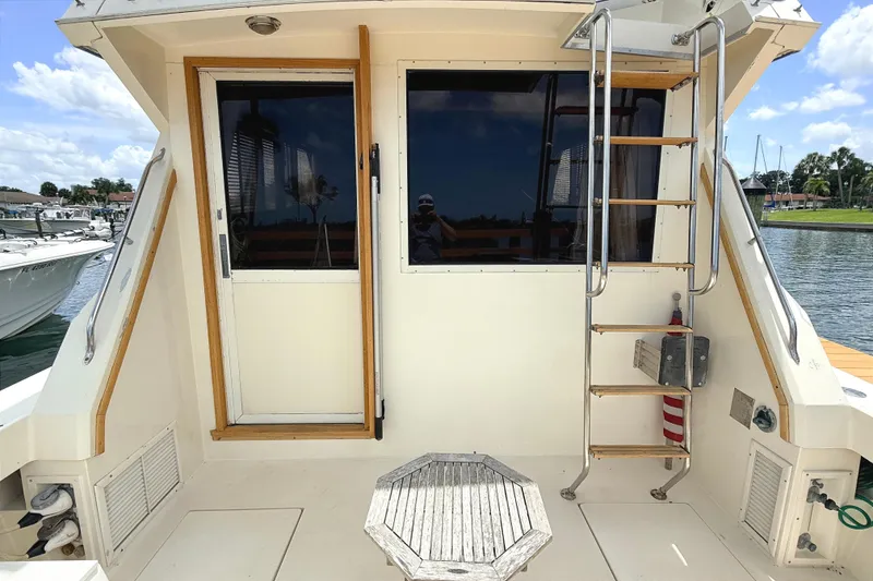 Slide: The Image of 1986 Viking 35 Convertible boat deck with ladder and door, docked by the water. - 3