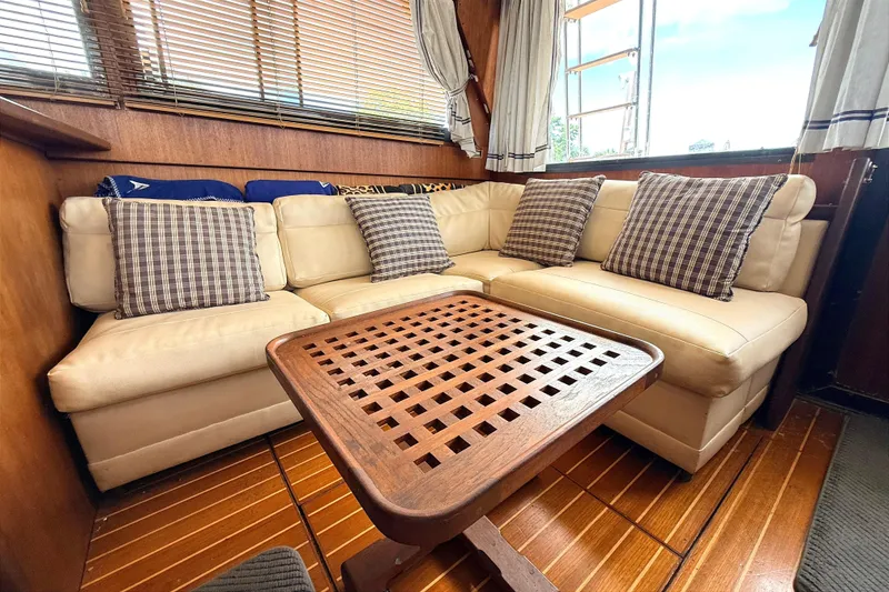 Slide: The Image of Cozy interior of 1986 Viking 35 Convertible with beige sofa and checkered pillows. - 6