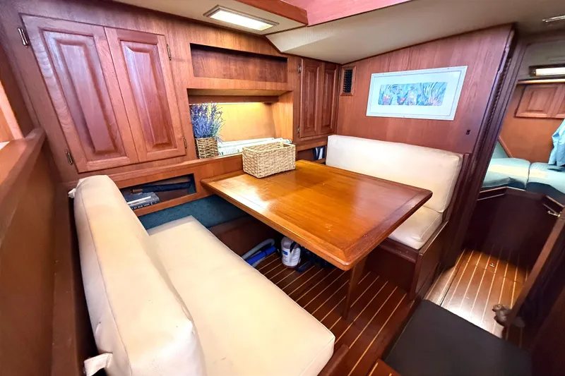 Slide: The Image of Interior of 1986 Viking 35 Convertible yacht with wooden dining area and cushioned seating. - 7