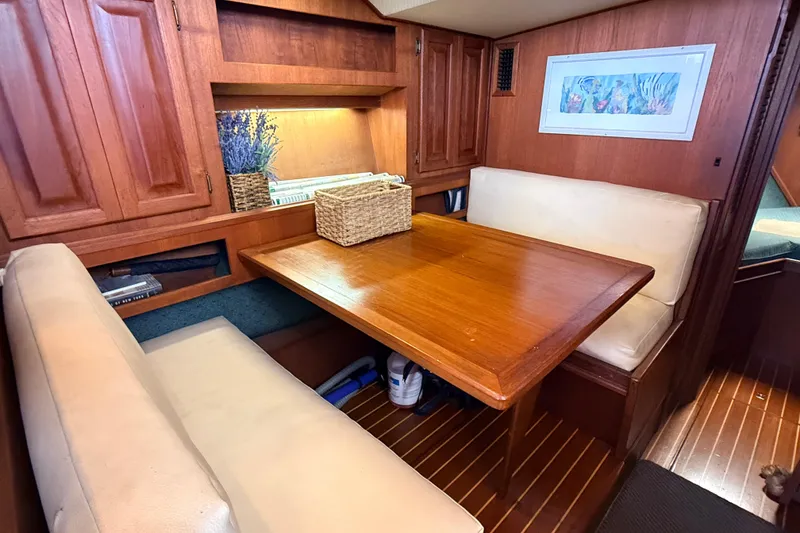Slide: The Image of Cozy dining area in 1986 Viking 35 Convertible yacht with wooden table and cushioned seating. - 8