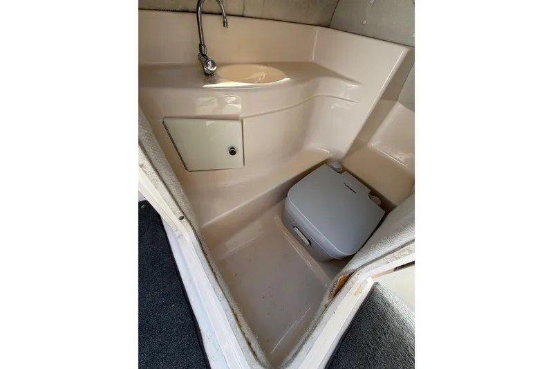 Slide: The Image of 2007 Regal 2400 Bowrider boat interior with sink and portable toilet. - 19