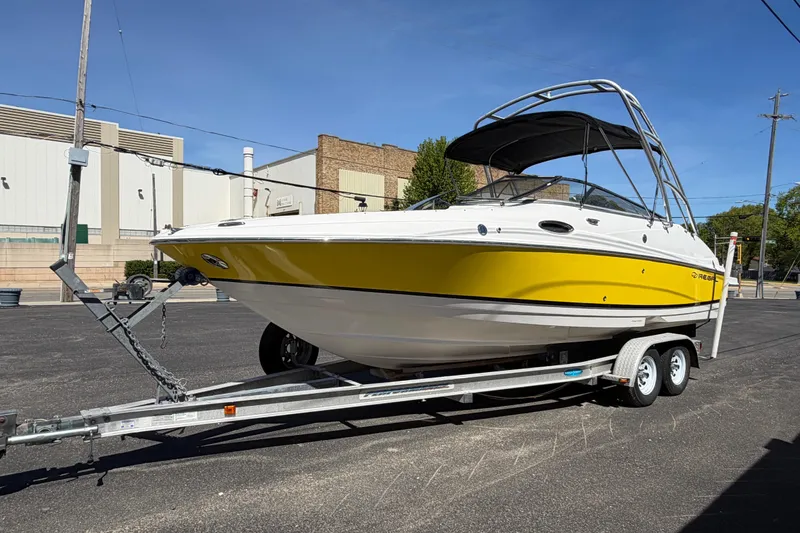 Slide: The Image of 2007 Regal 2400 Bowrider boat with yellow hull on trailer, parked outdoors. - 6