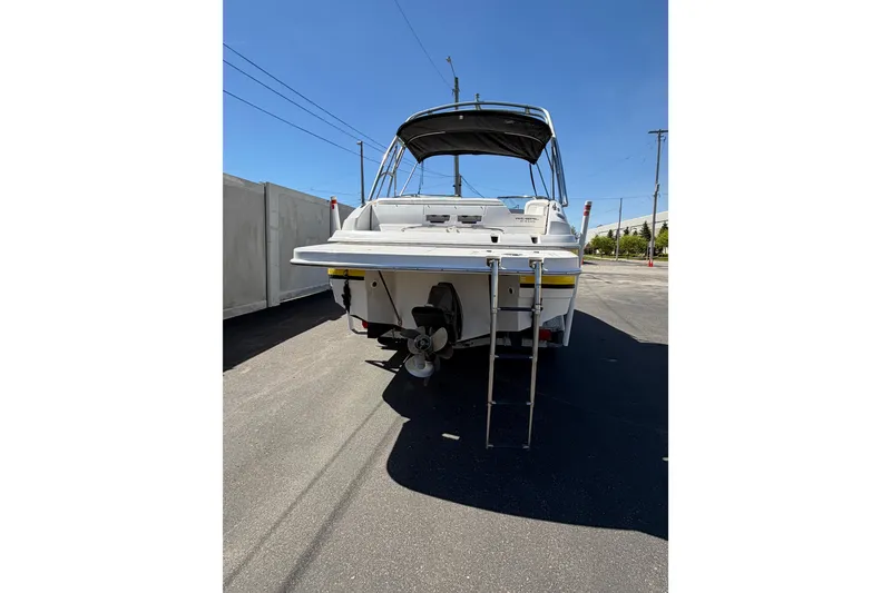 Slide: The Image of 2007 Regal 2400 Bowrider boat, rear view with ladder, parked outdoors. - 7