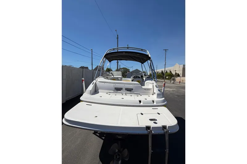 Slide: The Image of 2007 Regal 2400 Bowrider boat with swim platform and canopy, parked outdoors. - 8