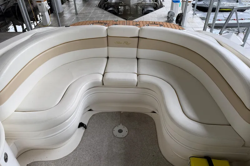 Slide: The Image of 2003 Sea Ray 290 Bowrider interior with white and beige seating arrangement. - 10