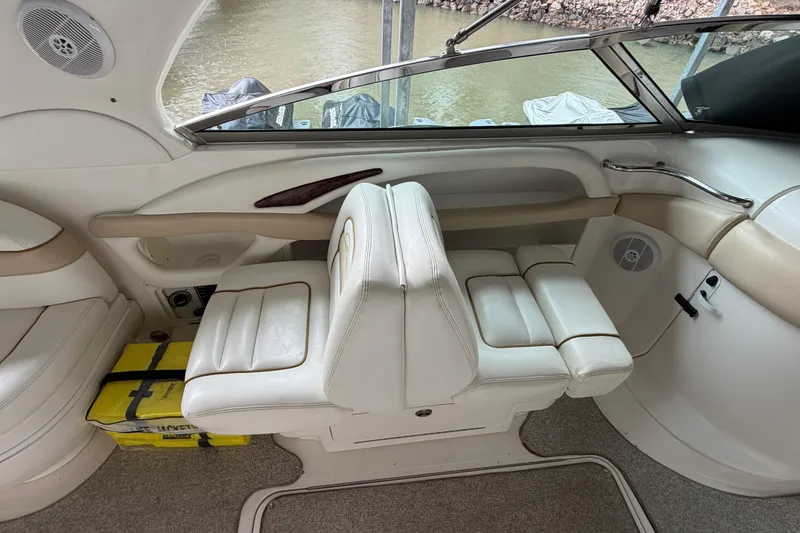 Slide: The Image of Interior of a 2003 Sea Ray 290 Bowrider boat with white seating and beige accents. - 16