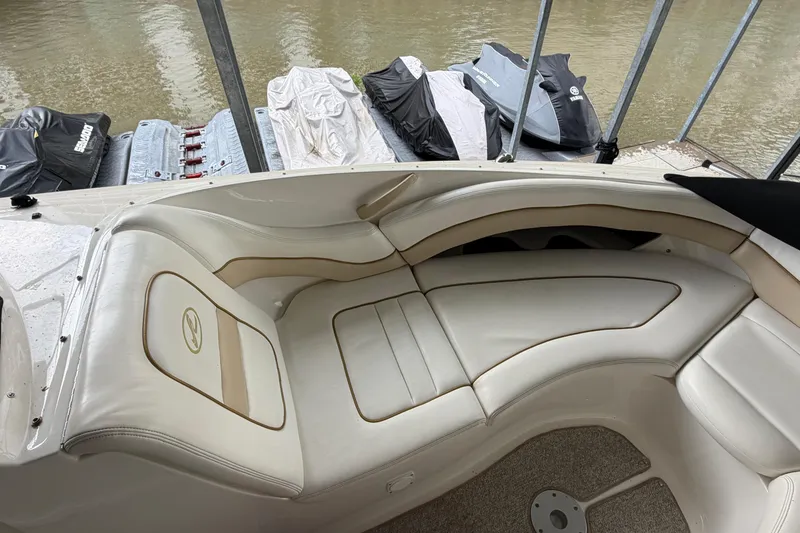 Slide: The Image of 2003 Sea Ray 290 Bowrider interior with white leather seating and docked jet skis. - 22