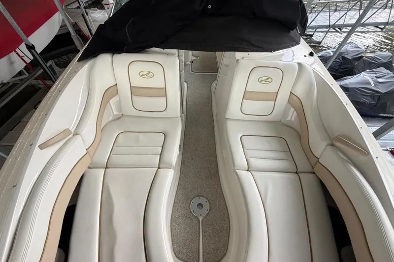 Slide: The Image of 2003 Sea Ray 290 Bowrider with white leather seating, docked in a marina. - 24
