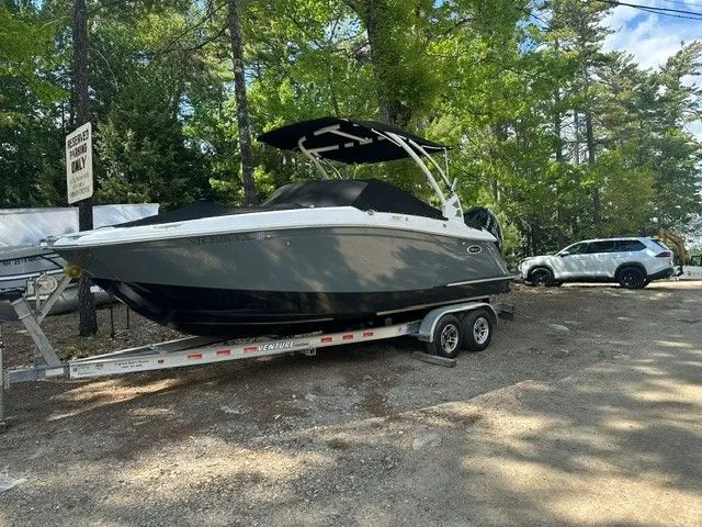 The Image of 2018 Cobalt 23 SC boat on trailer parked in wooded area. - 1