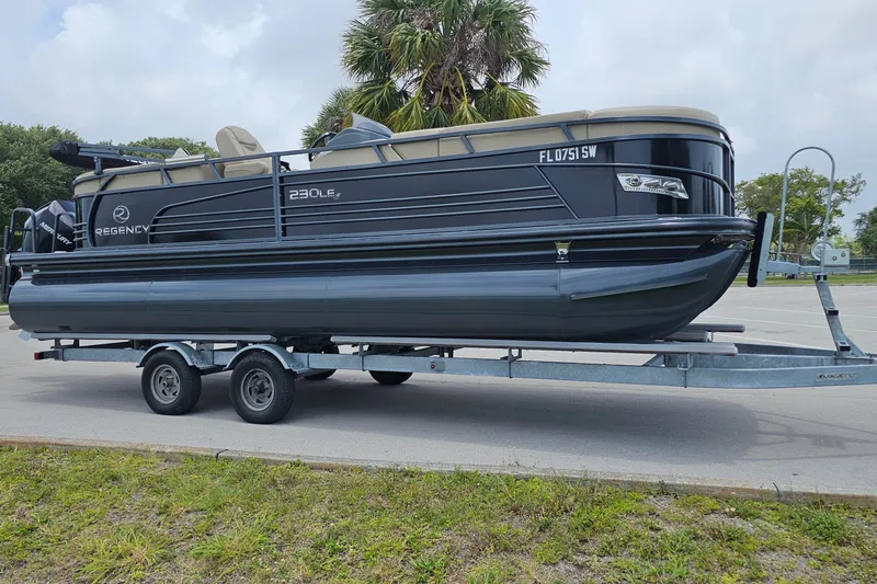 Slide: The Image of 2020 Regency 230 LE3 pontoon boat on trailer in parking lot. - 10