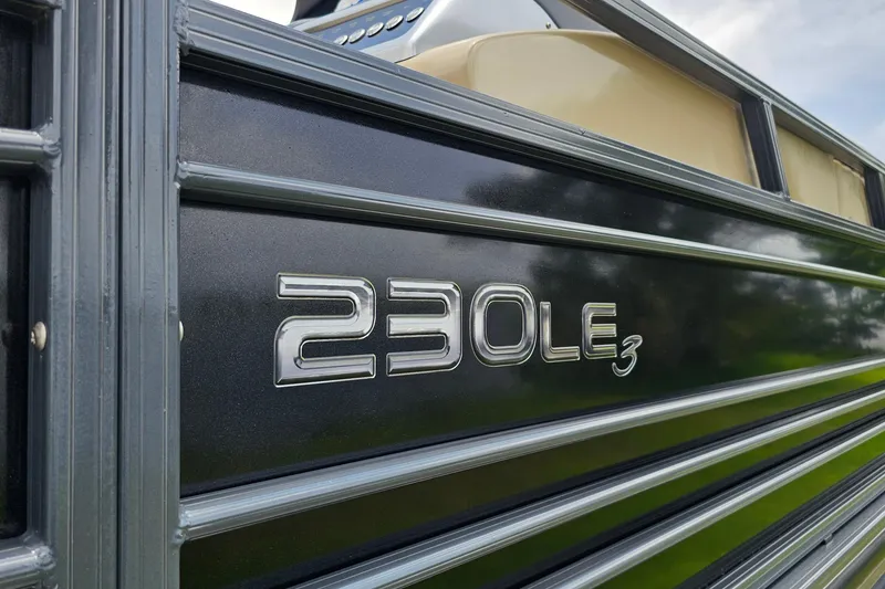 Slide: The Image of Close-up of 2020 Regency 230 LE3 boat model nameplate on sleek black panel. - 13