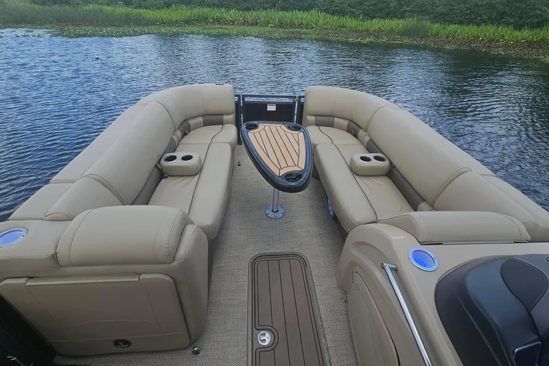 Slide: The Image of Luxurious 2020 Regency 230 LE3 pontoon boat interior with plush seating on a serene lake. - 23