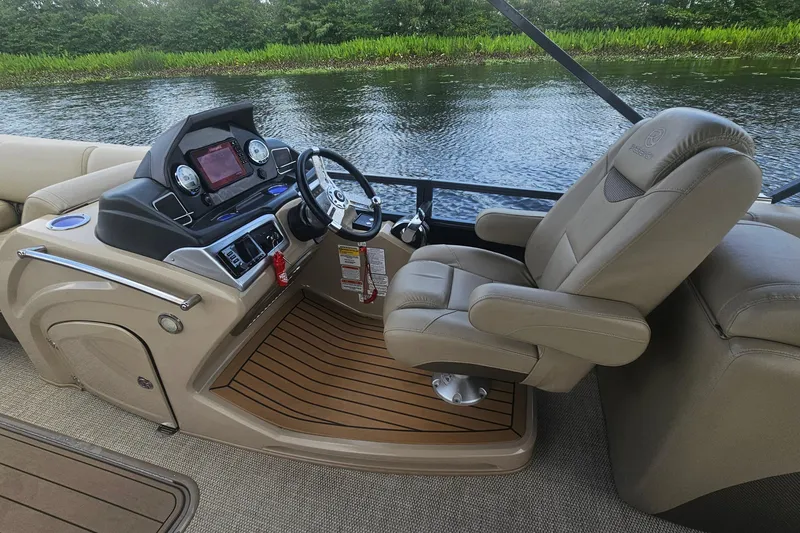 Slide: The Image of 2020 Regency 230 LE3 boat helm with luxurious captain's chair and modern dashboard controls. - 24