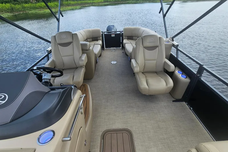 Slide: The Image of Luxurious 2020 Regency 230 LE3 pontoon boat interior with plush seating on a serene lake. - 26