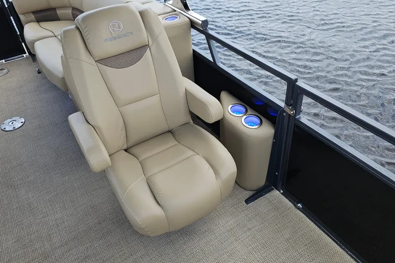 Slide: The Image of Luxurious seating on 2020 Regency 230 LE3 pontoon boat with cup holders, near water. - 27