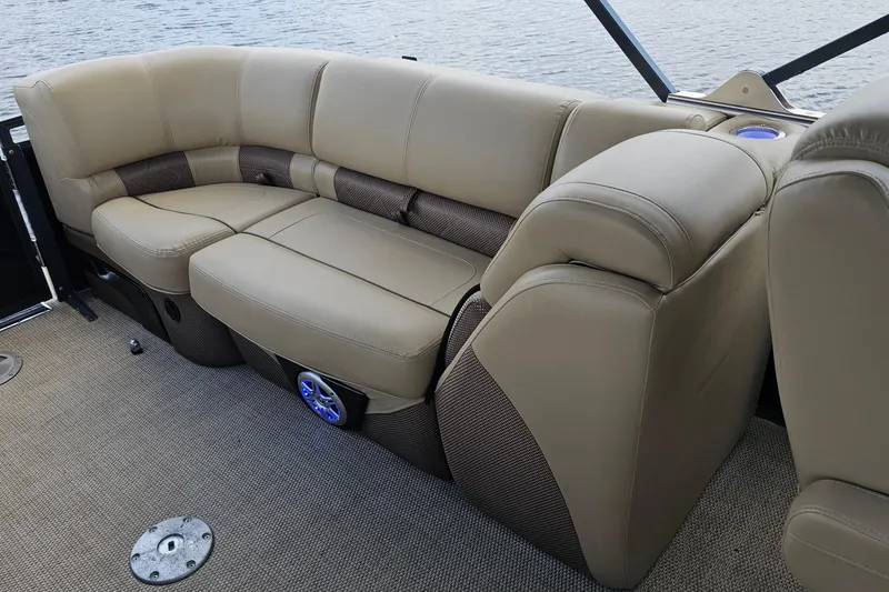Slide: The Image of Luxurious seating on 2020 Regency 230 LE3 pontoon boat, featuring beige upholstery and cup holder. - 28