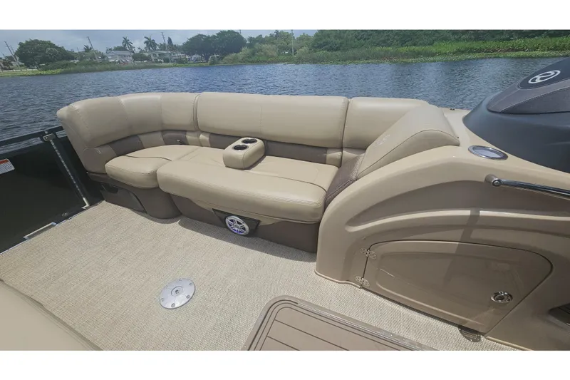 Slide: The Image of Luxurious seating on 2020 Regency 230 LE3 pontoon boat, featuring beige upholstery and cup holders. - 36