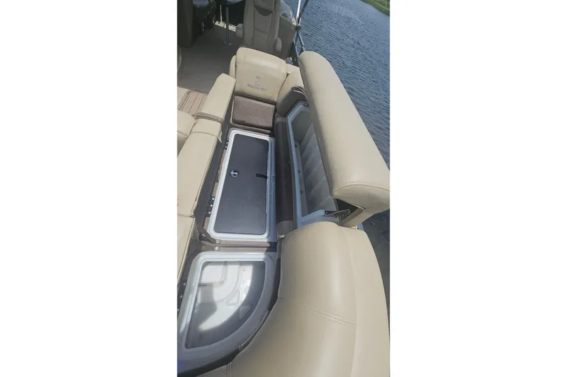 Slide: The Image of 2020 Regency 230 LE3 boat with open storage compartments on beige seating. - 39