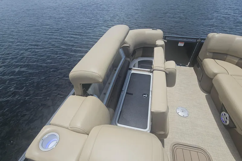 Slide: The Image of 2020 Regency 230 LE3 pontoon boat interior with beige seating and storage compartment. - 41