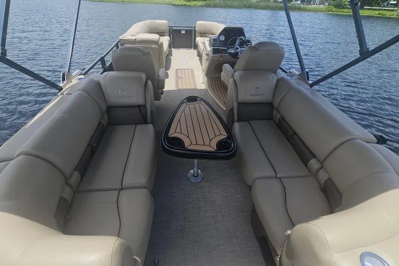 Slide: The Image of 2020 Regency 230 LE3 pontoon boat interior with beige seating and sleek design. - 48