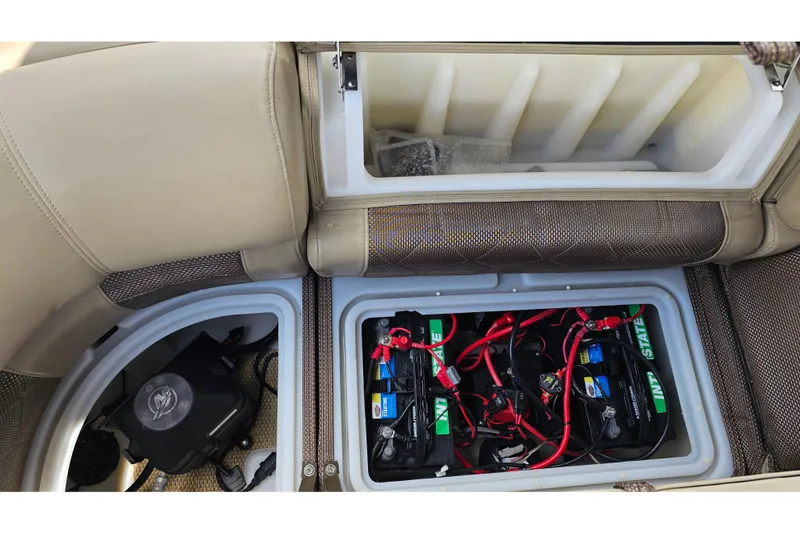 Slide: The Image of 2020 Regency 230 LE3 boat battery compartment with wiring and storage. - 49