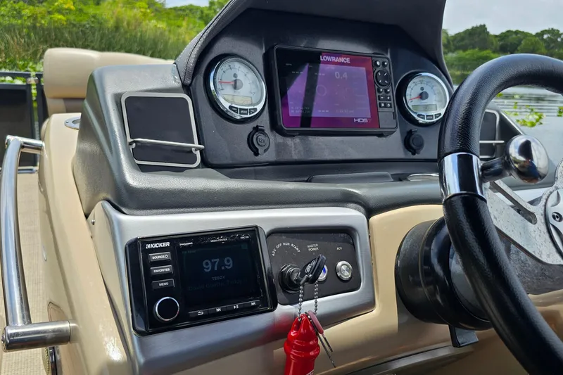 Slide: The Image of Dashboard of a 2020 Regency 230 LE3 boat with navigation and audio controls. - 56