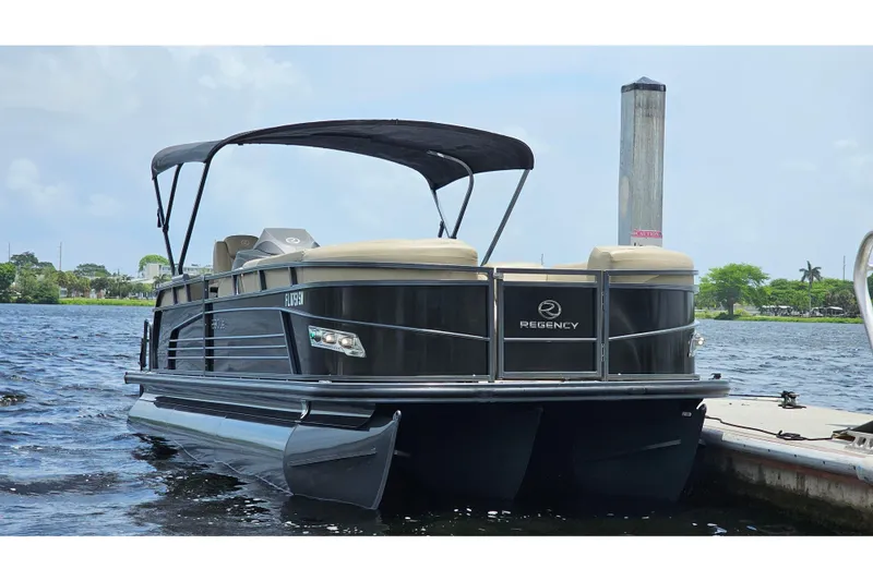 Slide: The Image of 2020 Regency 230 LE3 pontoon boat docked on a sunny day. - 63