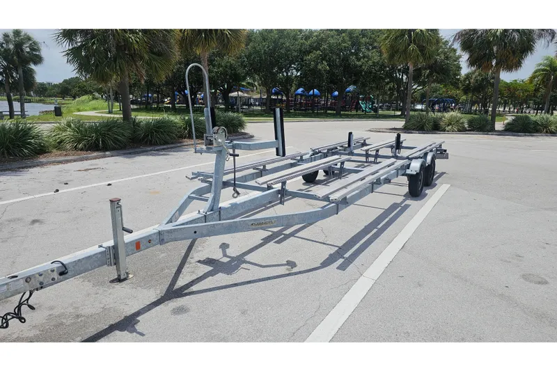 Slide: The Image of 2020 Regency 230 LE3 boat trailer parked in a sunny park setting. - 65