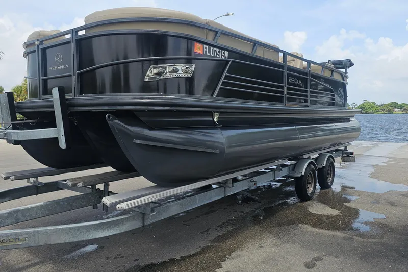 Slide: The Image of 2020 Regency 230 LE3 pontoon boat on trailer by waterfront. - 66
