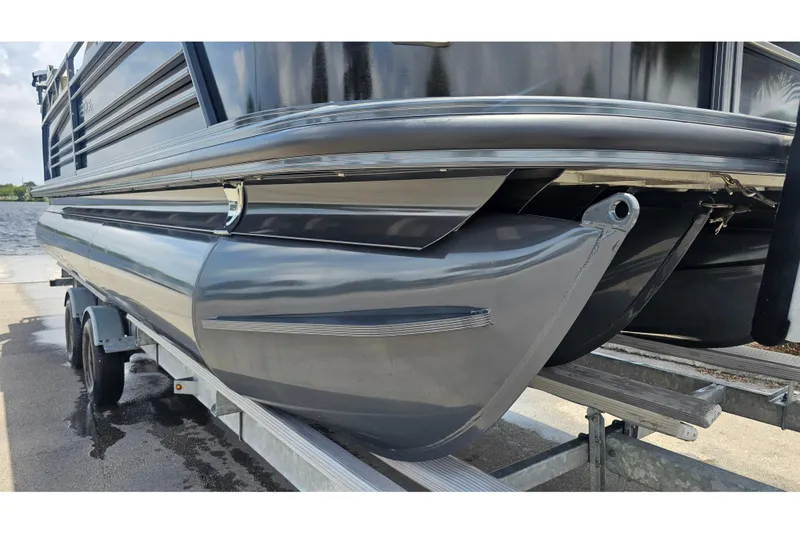Slide: The Image of 2020 Regency 230 LE3 pontoon boat on trailer, showcasing sleek design and sturdy construction. - 69