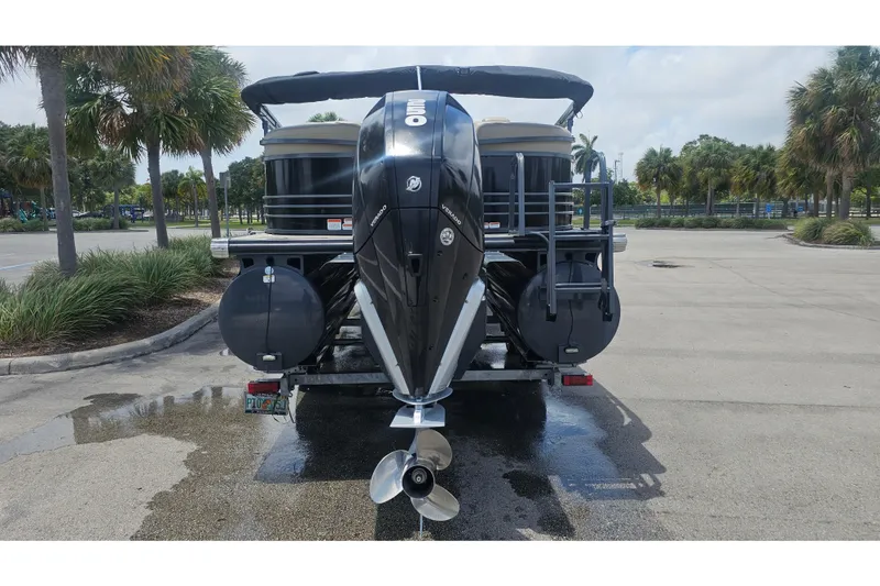 Slide: The Image of 2020 Regency 230 LE3 pontoon boat with Mercury outboard motor in a parking lot. - 70