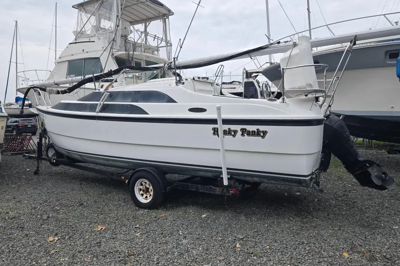 Slide: The Image of 2005 MacGregor 26 sailboat on trailer, parked on gravel lot. - 4