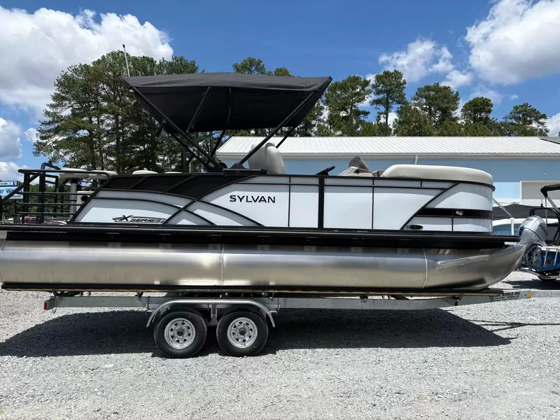 The Image of 2026 Sylvan X-3 DLZ BAR pontoon boat on trailer, side view. - 1