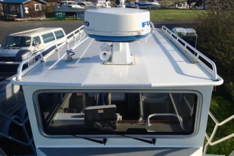 Slide: The Image of 2008 ACB 28 Explorer boat with radar equipment, parked near vehicles. - 2