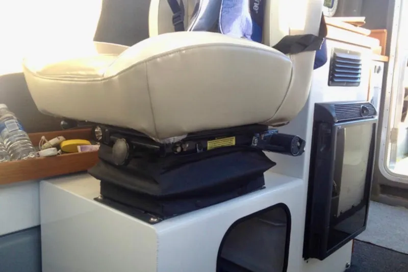 Slide: The Image of Captain's chair in 2008 ACB 28 Explorer boat interior, with storage and mini-fridge. - 20