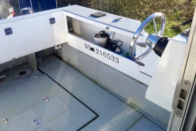 Slide: The Image of Interior of a 2008 ACB 28 Explorer boat showing steering wheel and storage compartment. - 3