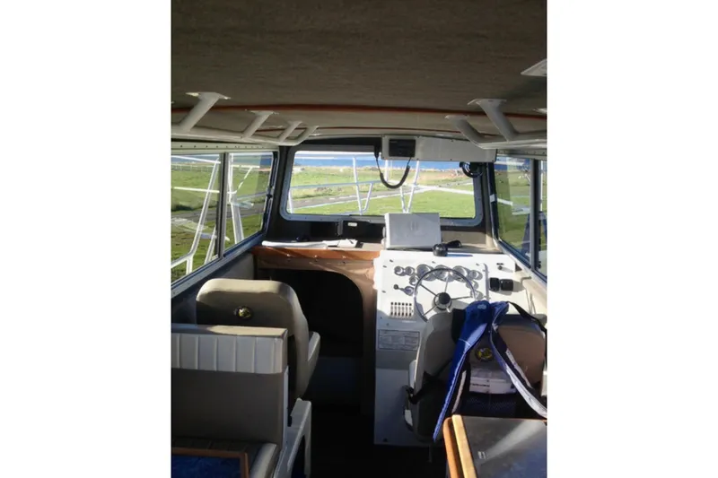 Slide: The Image of Interior view of 2008 ACB 28 Explorer boat cockpit with steering wheel and seating. - 4
