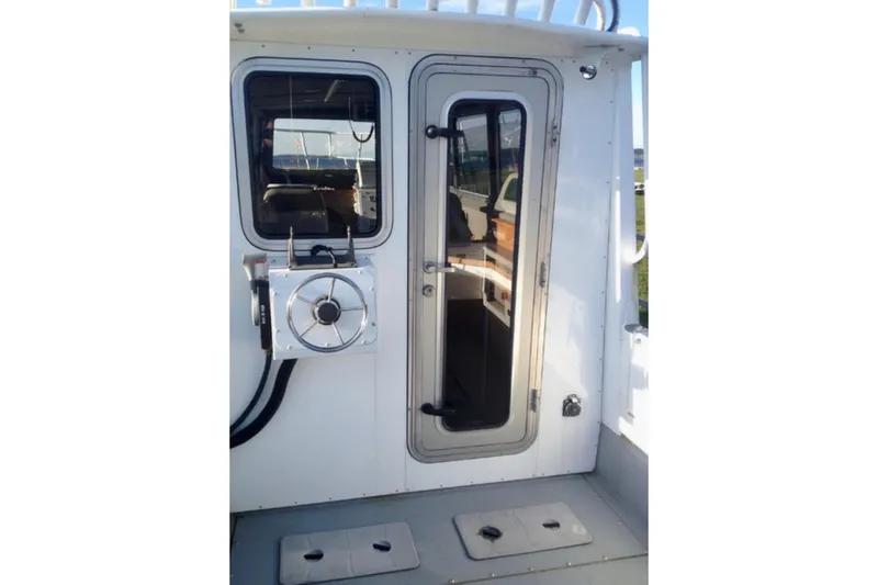 Slide: The Image of 2008 ACB 28 Explorer boat cabin entrance with steering wheel and window. - 7