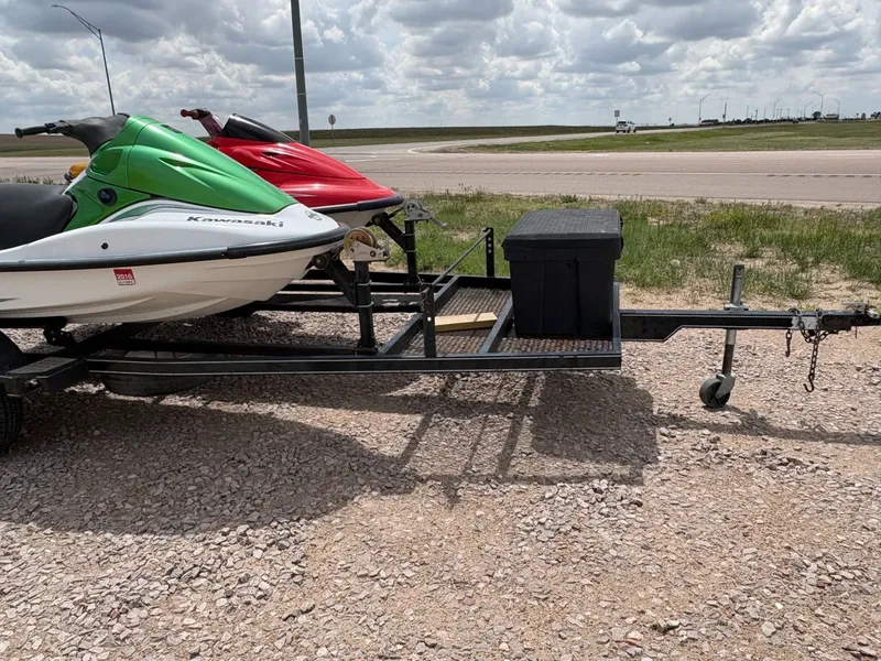 Slide: The Image of 2003 Kawasaki 1200 STX-R jet skis on trailer, cloudy sky. - 4