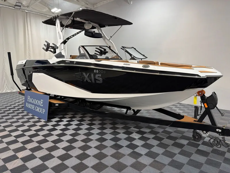 Slide: The Image of 2026 Axis A245 boat on trailer in showroom. - 2