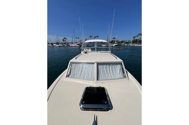 Slide: The Image of 1966 Chris-Craft 27 Commander boat docked in a marina under clear blue skies. - 12