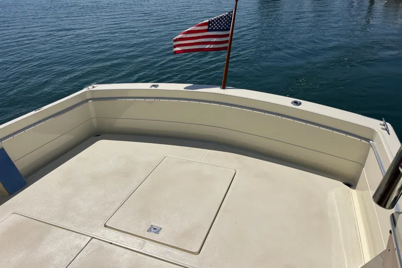 Slide: The Image of 1966 Chris-Craft 27 Commander boat deck with American flag, overlooking calm water. - 16