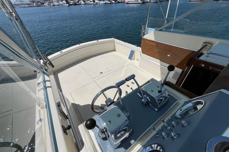 Slide: The Image of 1966 Chris-Craft 27 Commander boat cockpit with steering wheel and controls, docked in marina. - 19