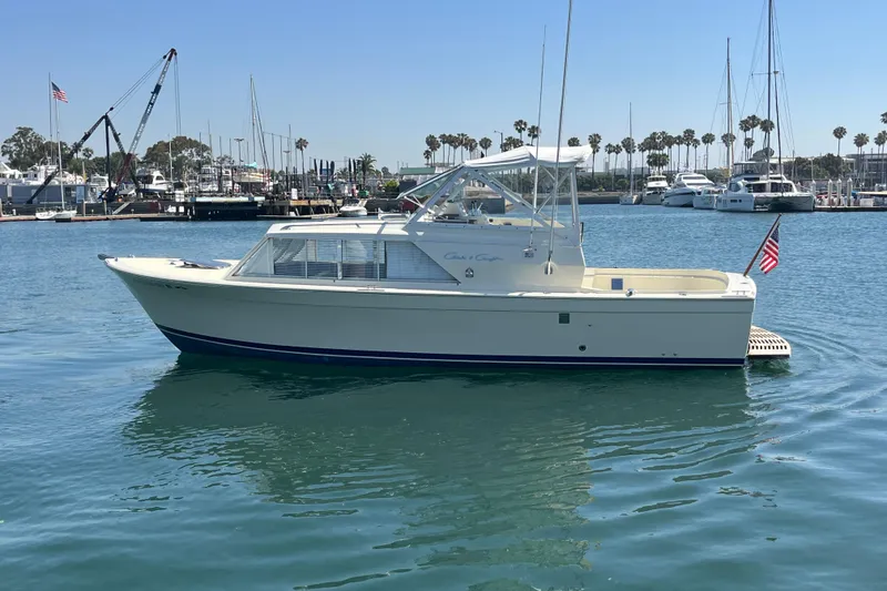 Slide: The Image of 1966 Chris-Craft 27 Commander boat docked in a marina with clear blue water. - 2