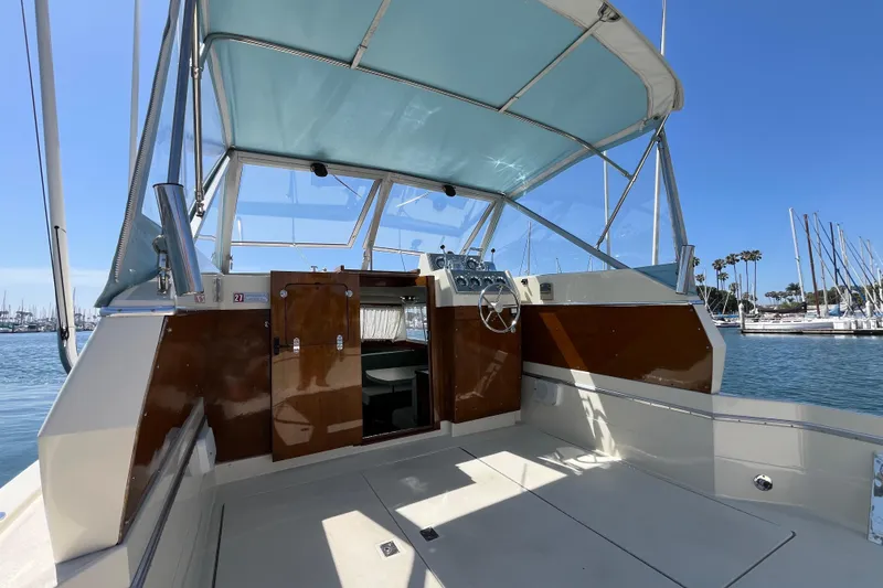 Slide: The Image of 1966 Chris-Craft 27 Commander boat interior with helm, docked in sunny marina. - 21
