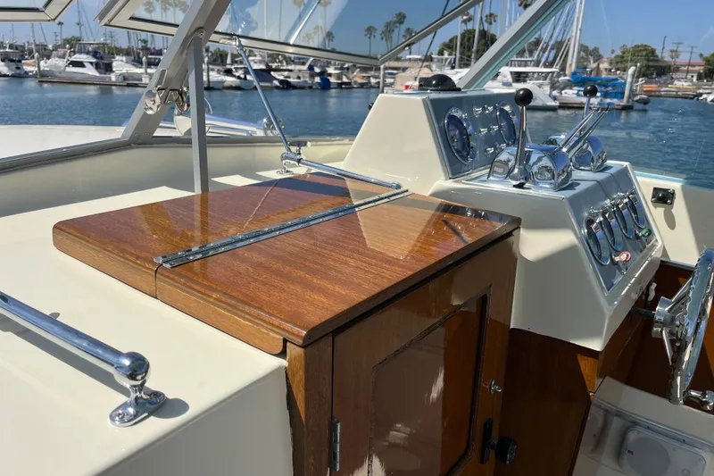 Slide: The Image of 1966 Chris-Craft 27 Commander helm with classic wood finish and chrome controls in marina setting. - 22