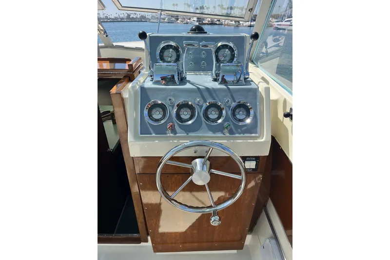 Slide: The Image of 1966 Chris-Craft 27 Commander helm with vintage gauges and steering wheel. - 24